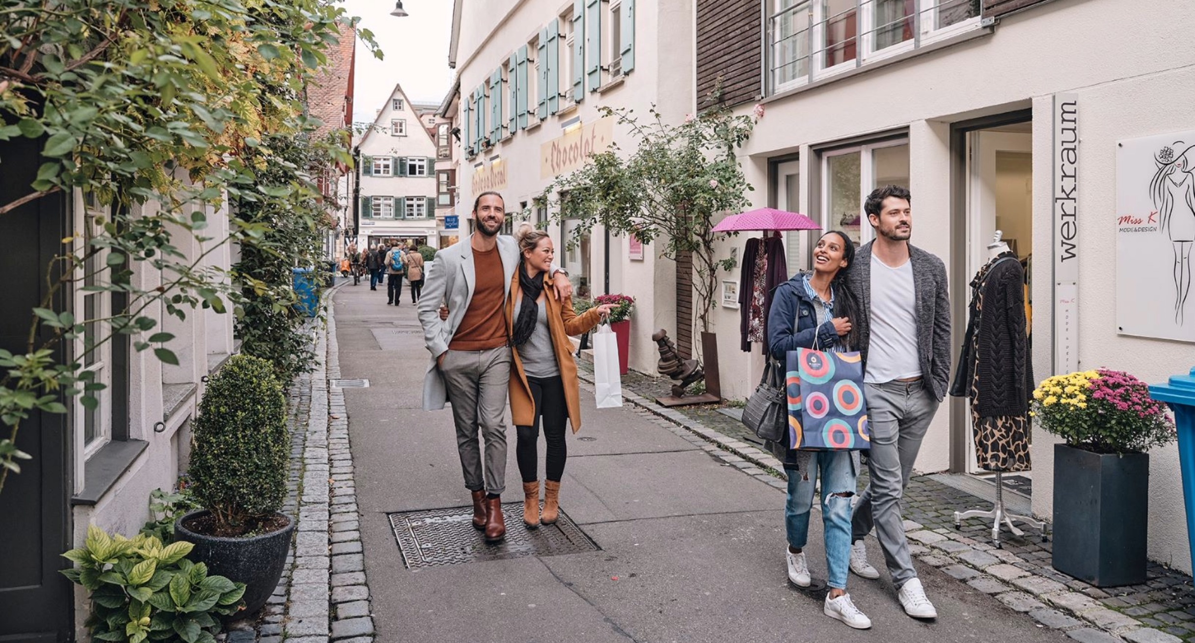 Das Bild zeigt junge Menschen, die durch die Altstadt Ulms flanieren